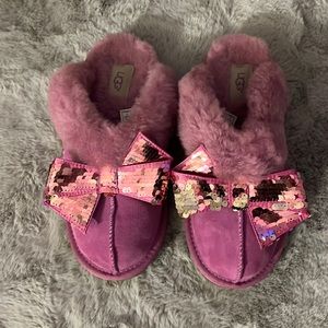 Pink Ugg slippers with a sequin bow on each slipper